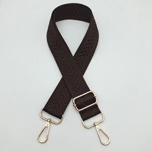Détail de la bandoulière chevrons marron avec mousquetons en métal doré réglables
