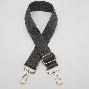 Détail de la bandoulière tressée gris foncé avec mousquetons dorés et boucle de réglage