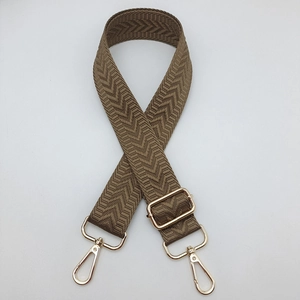 Détail de la bandoulière large réglable kaki avec crochets en métal doré et tissage à chevrons