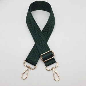 Détail de la bandoulière réglable vert foncé avec boucles dorées et motif à chevrons