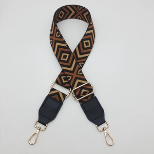Close-up of geometric diamond weave canvas strap with gold metal rotating hooks