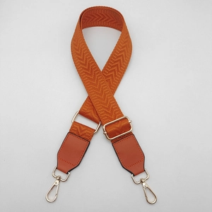 Detail of orange chevron canvas strap with golden swivel hooks and leather reinforcements