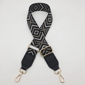 Detail of adjustable wide canvas shoulder strap with geometric diamond weave and gold buckles