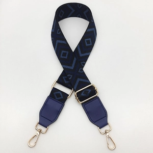 Close-up of diamond pattern canvas strap with blue leather ends and gold metal hooks