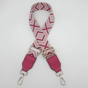 Close-up of geometric diamond pattern wide canvas bag strap with gold metal swivel hooks