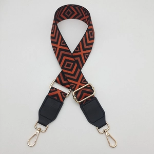 Detail of adjustable wide canvas shoulder strap with orange geometric diamond pattern