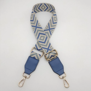 Close-up of geometric diamond pattern canvas bag strap with gold metal buckles