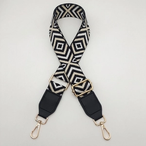 Detailed macro view of geometric diamond woven canvas strap with gold metal lobster clasps