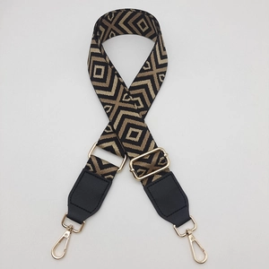 Detail view of wide adjustable canvas strap with gold lobster clasps and diamond pattern