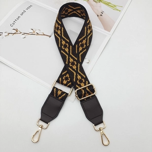 Detail view of ethnic jacquard woven shoulder strap with gold metal hooks and PU leather