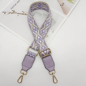 Close-up of woven bag strap with purple geometric pattern and gold swivel lobster clasps
