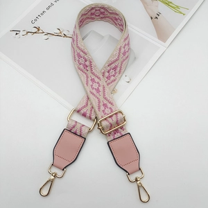 Close-up of pink geometric jacquard woven strap with golden metal clasp and leather end