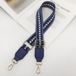 Détail de la bandoulière en nylon bleu avec motif flèche et crochets en métal doré