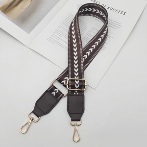 Détail de la bandoulière en nylon réglable avec motifs chevrons blancs et boucles dorées