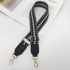 Détail de la bandoulière réglable en nylon à chevrons avec mousquetons dorés élégants