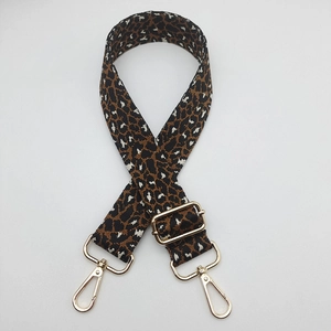 Close-up of leopard print bag strap with adjustable gold buckle and metal swivel hooks