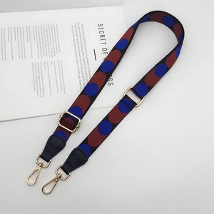 Macro detail of adjustable wide fabric bag strap with colorful polka dot patterns