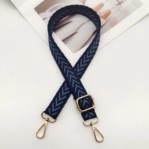Detail of blue chevron nylon bag strap with adjustable golden metal buckle and lobster clips