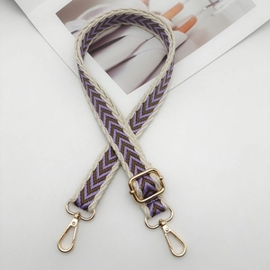 Detail of purple chevron woven bag strap with glossy gold lobster clasps and buckles