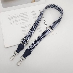 Close-up of adjustable wide woven shoulder strap with blue leather ends and silver metal hooks