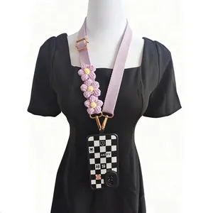 Detail of adjustable crochet flower lanyard and black white checkered phone case