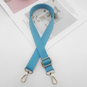 Vue détaillée de la bandoulière tressée bleu ciel avec boucles en métal doré poli