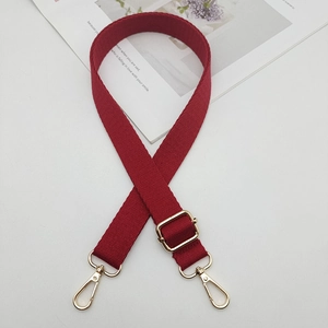 Détail de la bandoulière rouge ajustable avec des mousquetons et boucles en métal doré
