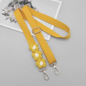 Detail of yellow woven shoulder strap with 3D daisies and silver metal swivel hooks