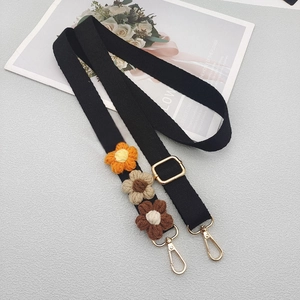 Adjustable black canvas strap with knitted flower motifs and gold metal hardware for bags
