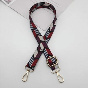 Detail of colorful geometric woven strap with premium gold metal hooks and buckle