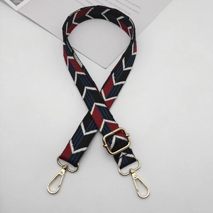 Close-up of adjustable colorful geometric pattern canvas shoulder strap with gold metal buckles
