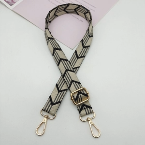 Detail of adjustable black and white chevron canvas strap with gold metal lobster clasps