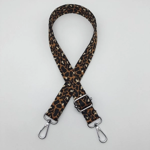 Detail of adjustable leopard print bag strap featuring silver metal spring hooks and buckle