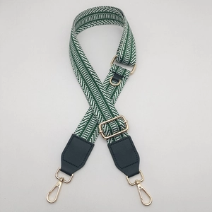 Detail of adjustable green and white geometric canvas strap with gold metal hooks