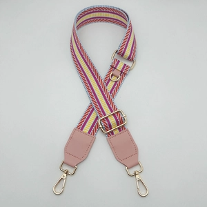 Close-up of adjustable striped canvas strap with pink leather ends and gold metal hooks