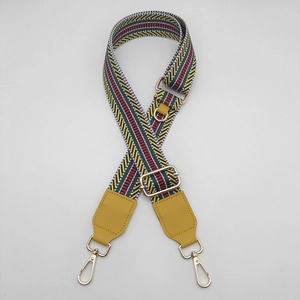 Detail of multi-color geometric striped canvas bag strap with golden metal clips