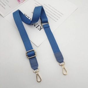 Detail of blue adjustable thick cotton strap with gold metal hooks for handbags