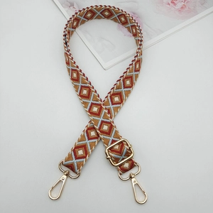 Detail view of 2.5cm geometric embroidered strap with golden metal lobster clasps