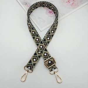 Detail of adjustable geometric diamond pattern shoulder strap with gold metal buckles