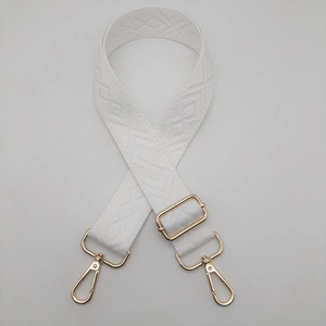Detail view of the white diamond pattern woven shoulder strap with gold metal hooks