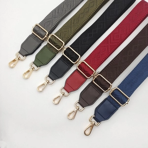 Detail view of woven adjustable bag straps in multiple colors with gold metal buckles