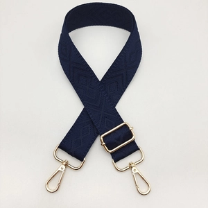 Close-up of navy blue geometric diamond woven adjustable shoulder strap with gold hooks