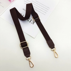 Close-up of thick dark brown cotton strap with golden metal hooks and leather connectors