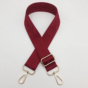 Detail of burgundy geometric rhombus woven strap with gold metal buckle and hooks