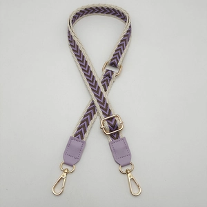 Close-up of adjustable woven shoulder strap with purple arrow patterns and gold hardware