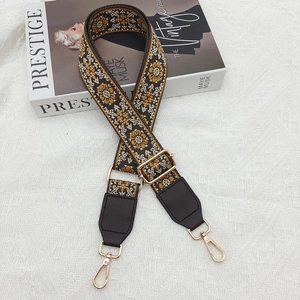 Detail of retro ethnic embroidered wide shoulder strap with golden metal lobster clasps
