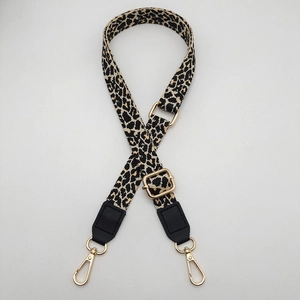 Detail of adjustable leopard print bag strap with gold metal hooks and black leather ends