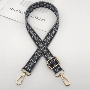Close-up of geometric jacquard woven bag strap with golden metal swivel hooks