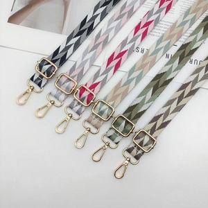 Detail of adjustable woven bag straps with chevron patterns and gold metal lobster clasps