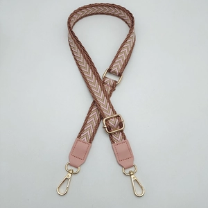 Detail of chevron woven shoulder strap with pink PU leather and gold metal hooks
